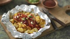 some food that is sitting in tin foil on a cutting board