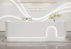 a white reception desk with a plant in it