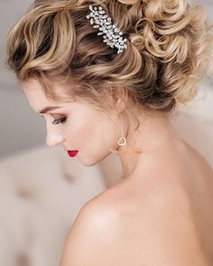 a woman with curly hair wearing a bridal headpiece and red lipstick on her lips