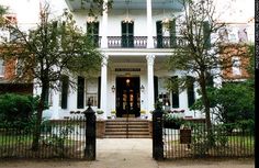 a large white house with black iron fence