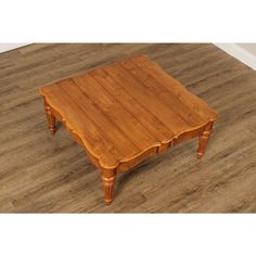 a wooden coffee table sitting on top of a hard wood floor