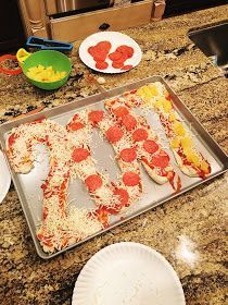 a homemade pizza with pepperoni and cheese on a baking sheet next to other ingredients