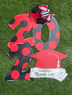 a sign that says congratulations thomas lee on the grass with a graduation cap and diploma