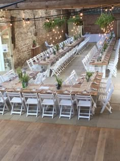 tables and chairs are set up in an indoor venue with string lights hanging from the ceiling