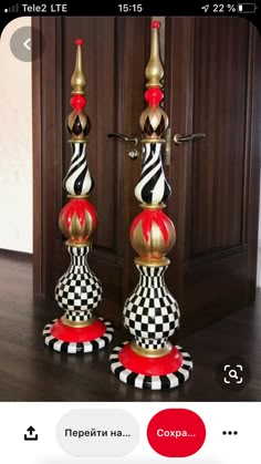 two black and white checkered candlesticks on top of each other in front of a wooden door