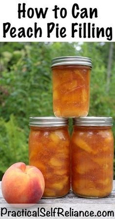 four jars filled with peach pie filling sitting on top of a wooden table next to an apple