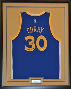 a jersey signed by the golden state warriors is displayed in a black framed shadow box