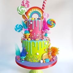 a multi - tiered birthday cake decorated with candy, candies and lollipops