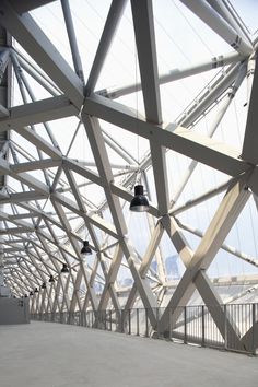 the inside of a building with several lights hanging from it's ceiling and metal beams