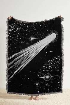 a black and white blanket with an image of a space shuttle flying through the sky