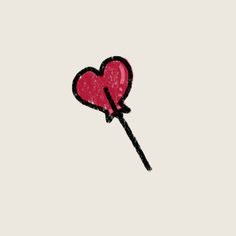 a heart shaped lollipop on a stick with a toothpick in it