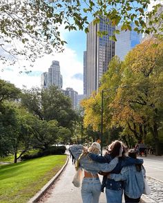 two women walking down the street with their arms around each other