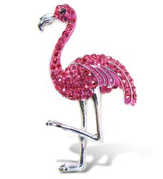 a pink flamingo brooch sitting on top of a white surface with its legs spread out