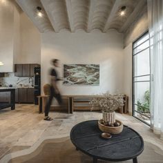 a living room filled with furniture and a painting on the wall above it's coffee table