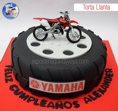 a birthday cake with a motorcycle on top of a tire and nameplate that reads yamaha