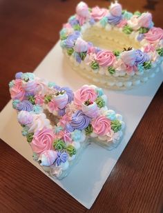 two cakes decorated with flowers on top of a table