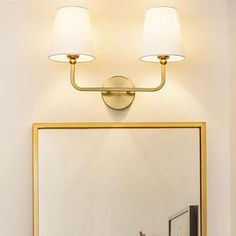 a bathroom vanity with a mirror and two lights on the wall next to a sink