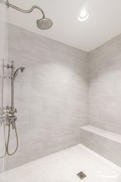 a bathroom with a walk in shower next to a white bathtub and tiled walls