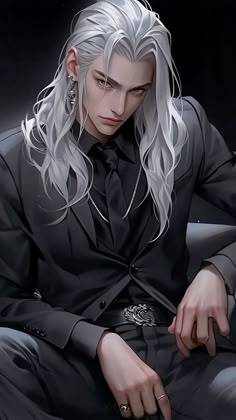 a man with long white hair sitting on top of a chair wearing a black suit