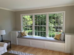 a living room filled with furniture and a large window sill next to a white couch