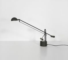 a black table lamp sitting on top of a white counter next to a light bulb