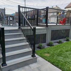 a metal stair rail on the side of a deck in front of a fenced yard