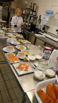 a chef preparing food in a kitchen with plates and bowls on the counter, along with other dishes