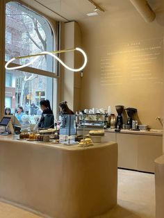 a woman is working at a counter in a coffee shop with a laptop on it