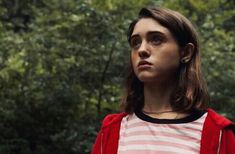 a woman in a red and white striped shirt stares into the distance