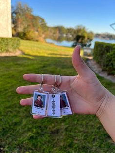 a person holding up two small tags in their hand with the same photo on them