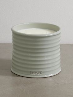 a white candle holder sitting on top of a table next to a gray countertop