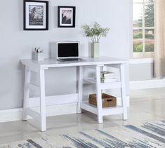 a white desk with a laptop on top of it next to a rug and pictures