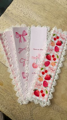 five paper napkins with strawberries and cherries on them sitting on a table