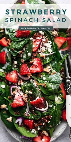 spinach salad with strawberries, onions and feta cheese in a white bowl