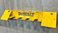 there is a yellow sign on the wall that says dewt and has holes in it