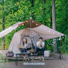 two people sitting in a tent on a picnic table