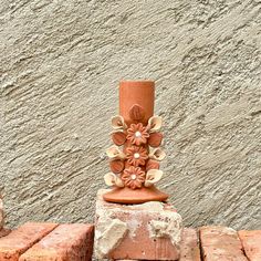 a vase sitting on top of bricks next to a cement wall with flowers painted on it