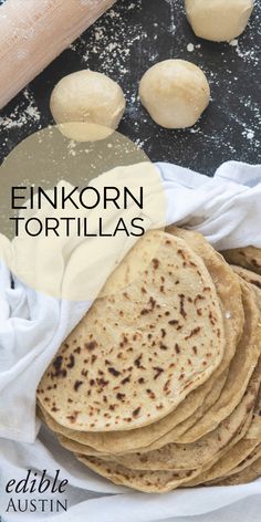 a stack of tortillas sitting on top of a table next to a rolling pin