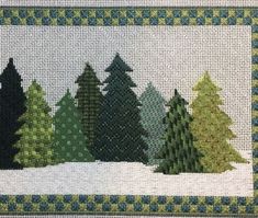 cross - stitched christmas trees in the snow on a white background with blue and green border