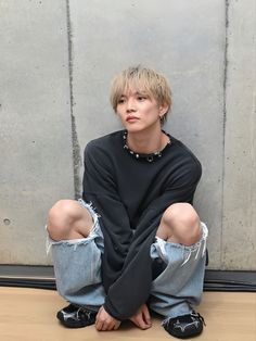 a person sitting on the ground with their legs crossed