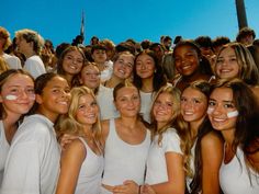 a group of young women standing next to each other in front of a blue sky