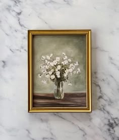 a painting of white flowers in a glass vase on a marble surface with gold frame