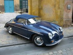 an old blue car is parked on the street