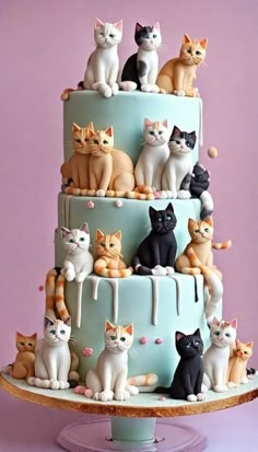 a multi layer cake decorated with cats on it's sides and the top tier is blue