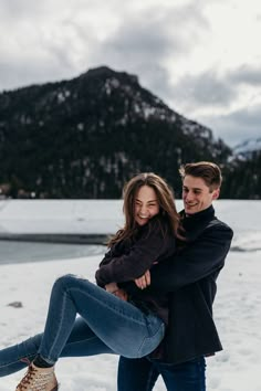 a man and woman are hugging in the snow