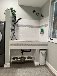 a washer and dryer in a room with tile flooring, white walls