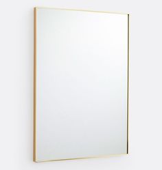 a mirror mounted to the side of a wall next to a white wall with a yellow frame