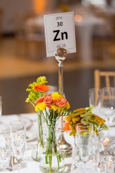 the table is set with flowers and glasses