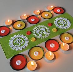 some candles are sitting on top of a green mat with white and red circles around it