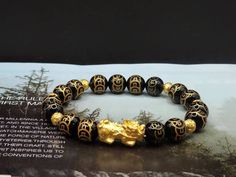 Gift yourself or your loveonce this beautiful Pure Gold Feng Shui Pixiu Bracelet.  *Materials: Au999 Pure Gold, Onyx Stone *Karat: 24K Pure Gold  *Gold Color: Yellow *Gold Weight: Approximately 1.71g - 1.75g SIZE Pixiu Length: .82 Inches Pixiu Width: .38 Inches Mantra Ball: 6mm Onyx Stone: 10mm 🔸️Pi Xiu has the meaning of bringing in wealth and treasure. Of course, it is capable of warding off evil spirits and bringing good fortune.  🔸️Money Ball is used to attract good fortune and money luck, Symbolic Gold Bracelets For Festivals, Spiritual Gold Bangle Bracelet As Gift, Gold Spiritual Crystal Bracelet, Spiritual Yellow Gold Beaded Bracelets As Gift, Gold Spiritual Crystal Bracelet For Gift, Gold Spiritual Crystal Bracelet For Wedding, Symbolic Gold Beaded Bracelets As Gift, Spiritual Gold Bracelet With Round Beads As Gift, Gold Spiritual Wristband With Round Beads